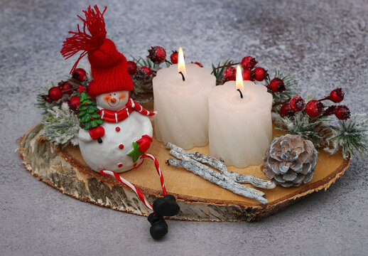 Rustikale Weihnacht und Adventsdekoration mit Kerze und Weihnachtsschmuck.