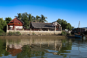 Obraz premium Charming village along the river in Morondava, Madagascar, showcasing local architecture and serene waters in bright daylight