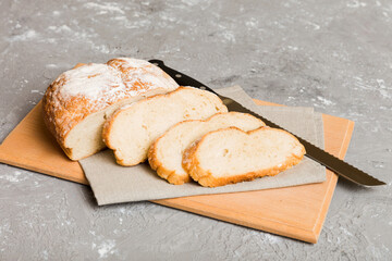 Assortment of freshly sliced baked bread with napkin on rustic table top view. Healthy unleavened bread. French bread slice