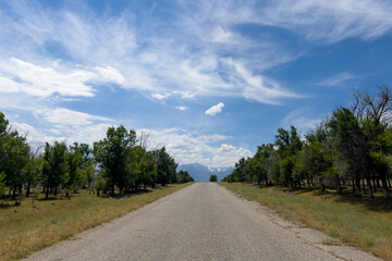Landscape asphalt road goes to the horizon and cloudy blue sky