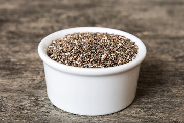 Chia seeds in bowl on colored background. Healthy Salvia hispanica in small bowl. Healthy superfood