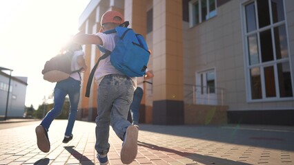 A group of girls running back to school. Bag elementary happy concept. Children running around in a...