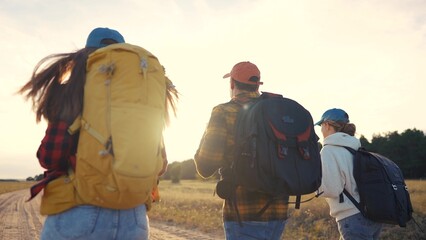 Fototapeta premium Three tourists walk together, working as a team. Mountain people hike concept. Group of tourists traveling in backpacks. Two tourists in a lifestyle group are walk together in backpacks.