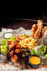 variety of fried foods including chicken strips, French fries, and other appetizers served with...