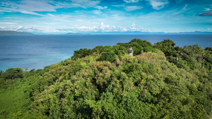 Aerial view of Nosy Iranja Island showcasing lush greenery and tranquil waters in Madagascar under a bright blue sky