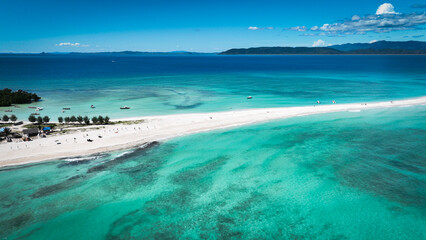 Aerial view of Nosy Iranja Island in Madagascar showcasing crystal-clear waters and stunning white sandy beaches on a sunny day