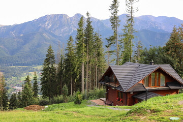 ZAKOPANE, POLAND - AUGUST 22, 2024: A wooden house with a view of the Tatra Mountains.