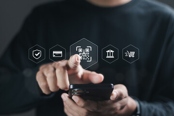 Businessman using smartphone with QR code icon on virtual screen. QR code scan for website or mobile application customer support, digital payment. Technology for bank business and Investment.