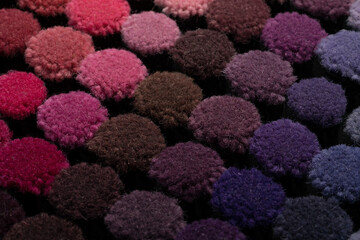 Textile industry concept. Close up isometric shot of multiple colorful carpet textile samples. Color palette variations of pink and purple shades.