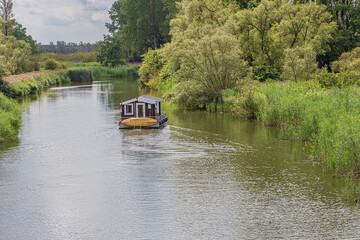 Houseboat navigating on a small canal in the Biesbosch National Park