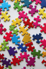 Colorful jigsaw puzzle pieces on white background. Flat lay.