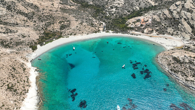 Aerial drone photo of paradise blue bay of uninhabited island of Polyaigos with turquoise crystal clear sea visited by luxury yachts and sail boats resembling a blue lagoon, Cyclades, Greece