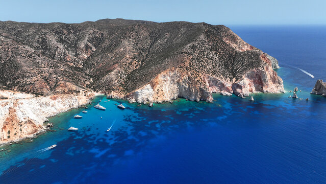 Aerial drone photo of paradise blue bay of uninhabited island of Polyaigos with turquoise crystal clear sea visited by luxury yachts and sail boats resembling a blue lagoon, Cyclades, Greece