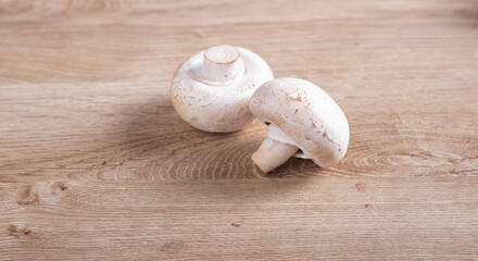 White champignons cut on wooden table in kitchen