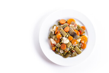 vegetable stew (menestra de verduras) on a plate isolated on white background. Top view. Copy space