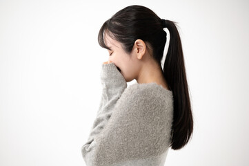 ニットを着て顔を隠す女性