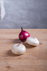 Red and white onions on a wooden table in the kitchen