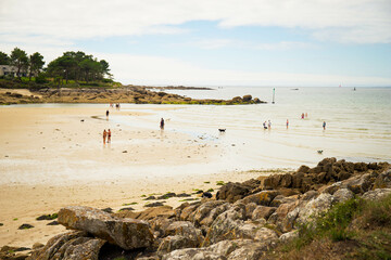 People, not recognizable, enjoying  Plage de Minaouet beach during low tide. Finistere, Brittany, France.