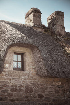 Detail of a traditional thatched roof cottage house in the charming Village of Kerascoet (Krascot), Brittany (Bretagne), France. Vertical shot.