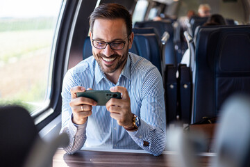 Man Enjoying Mobile Game on Train Journey