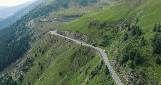Aeriel Drone View of the Transfagarasan Highway in the Carpathian Mountains of Transylvania in summer with green forest and grass. Winding Road with cars driving in 4K