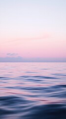 Obraz premium Calm Glassy Sea Water at Dawn with Soft Pink and Purple Reflections