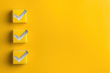 Three yellow square boxes each with a silver checkmark on a vibrant yellow background with ample negative space for design use
