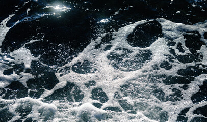 Waves and sea foam at the seashore. Natural background.