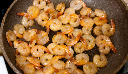 Shrimp fried in pan at home. Selective focus with shallow depth of field.