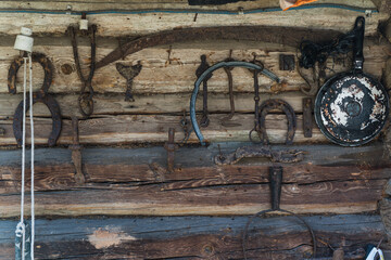 Old Slavic tools and tools hang on the wall of a log house