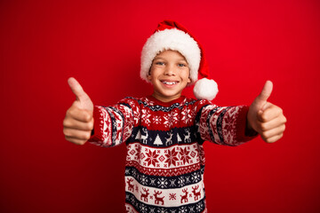 Photo portrait of charming small boy thumb up approve celebrate christmas dressed knitted sweater isolated on red color background