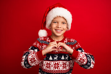 Photo portrait of charming small boy show heart symbol celebrate christmas dressed knitted sweater isolated on red color background