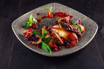 Roasted duck breast with pear and red currant sauce on plate