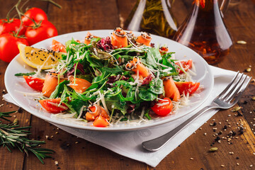 Delicious salad with arugula and salmon served on wooden table