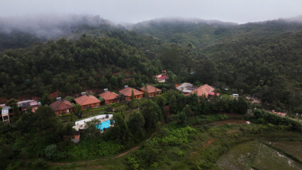 Serene aerial view of Andasibe, Madagascar showcasing lush greenery and tranquil accommodations surrounded by misty hills