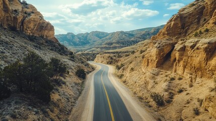 Imagine a road that traverses a rugged canyon, with dramatic rock formations and steep cliffs rising on either side.