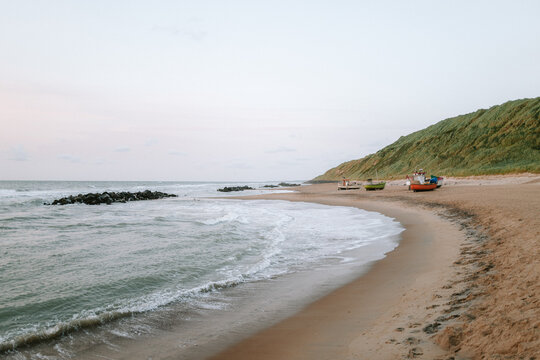 Strand von L&oslash;nstrup mit Fischerbooten in D&auml;nemark bei Sonnenuntergang