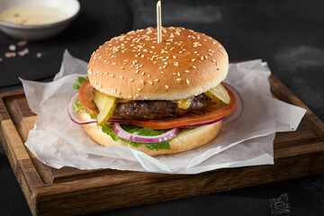 Juicy Beef Patty Burger on Rustic Wooden Board with Dark Background - Gourmet Food Photography