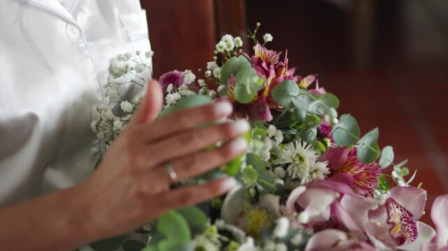 Hispanic bride holding colorful bouquet of Peruvian lilies. Astromelias. Elegant wedding details.
