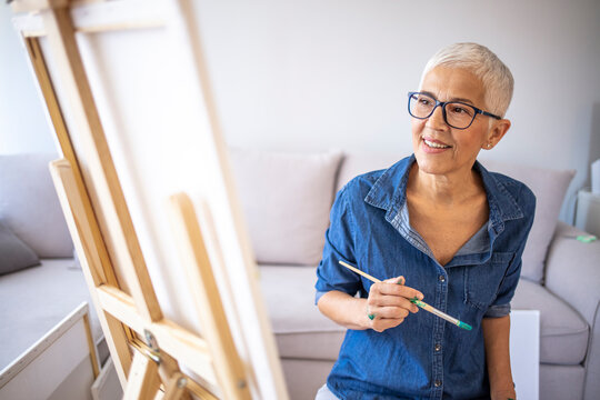 Mature Woman Joyfully Painting in Casual Home Setting