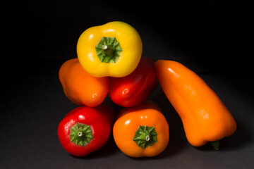 Colorful peppers on a black background. Studio photography of vegetables.