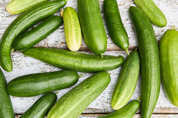 Freshly harvested cucumbers on rustic wooden background, showcasing gardening produce