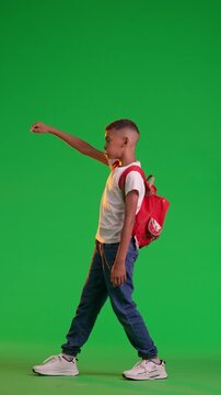 Young Boy Striking a Superhero Pose Against at the green Screen