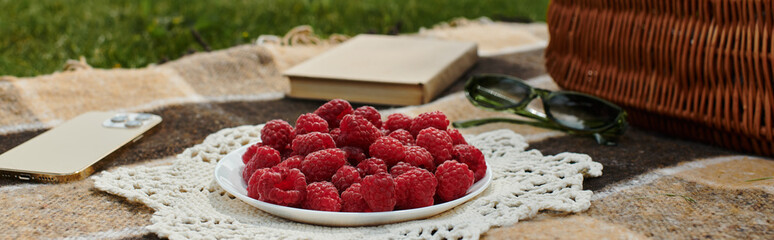a sunny summer picnic, surrounded by fresh raspberries and lush greenery.