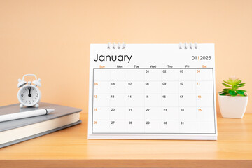 January 2025, Monthly desk calendar for 2025 year on wooden table.