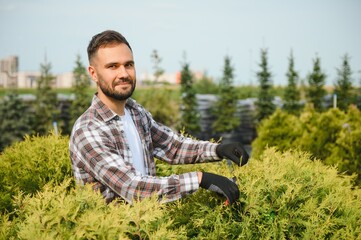 Obraz premium Portrait of a young handsome gardener. Shop of tree sprouts.