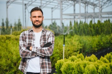 portrait of a young gardener on a plantation of bush seedlings.