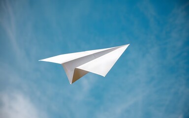 A photo of a paper airplane in mid-flight against a clear blue sky.