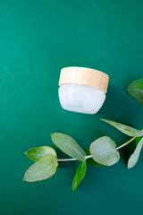 Natural cosmetics concept, cream jars over dark green background