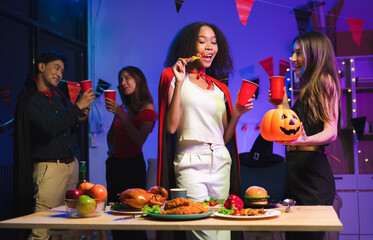 Dinner and group of people celebrating together at Halloween party. Friends are happy and celebrating with food, wine and friendship of love and cheers of champagne at the event.